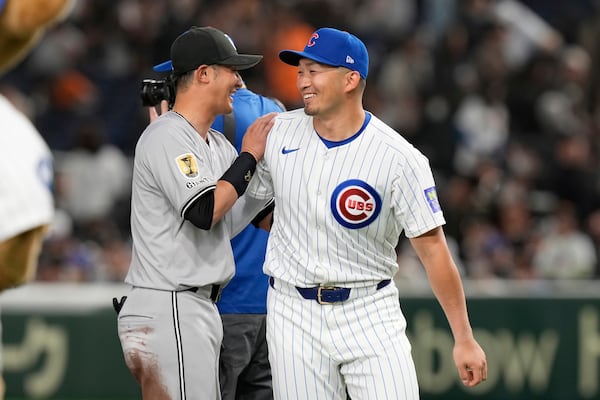 Yomiuri Giants' Naoki Yoshikawa, left, and Chicago Cubs' Seiya Suzuki, right, greet each other after their team's MLB Japan Series exhibition baseball game in Tokyo, Japan, Sunday, March 16, 2025. (AP Photo/Eugene Hoshiko)