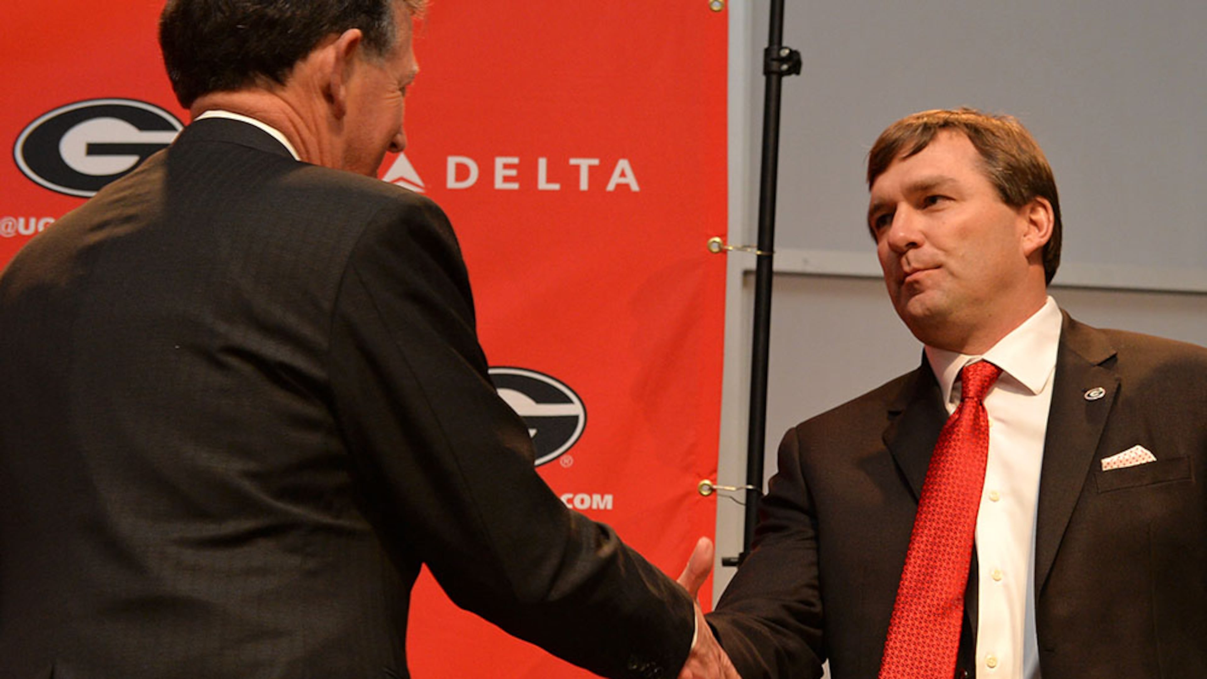 Georgia athletics director Greg McGarity cedes the podium to new head football coach Kirby Smart upon hiring him in 2015. (Brant Sanderlin/AJC 2015)