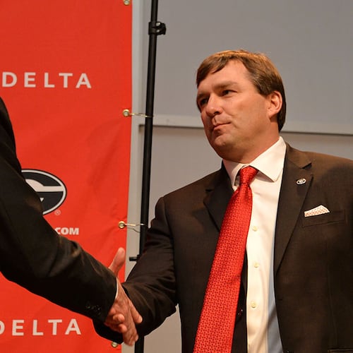 Georgia athletics director Greg McGarity cedes the podium to new head football coach Kirby Smart upon hiring him in 2015. (Brant Sanderlin/AJC 2015)