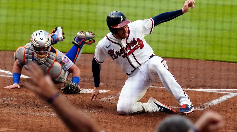 Atlanta Braves' Freddie Freeman (5) beats the tag from New York Mets catcher James McCann (33) to score on an Ozzie Albies base hit in the first inning of a baseball game Wednesday, June 30, 2021, in Atlanta. (John Bazemore/AP)
