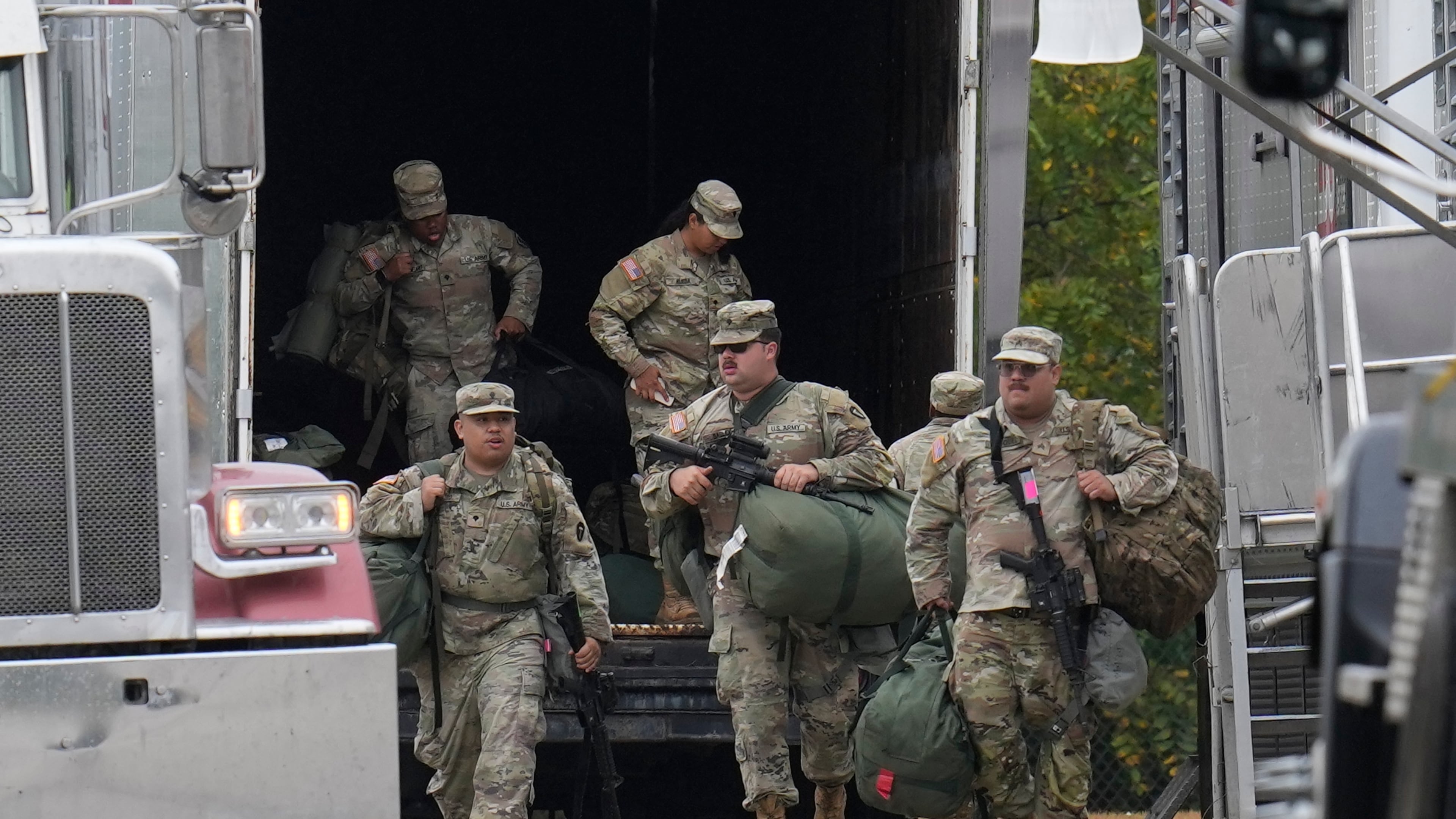 Military personnel in uniform, with the Texas National Guard patch on, are seen at the U.S. Army Reserve Center, Tuesday, Oct. 7, 2025, in Elwood, Ill., a suburb of Chicago. (AP Photo/Erin Hooley)