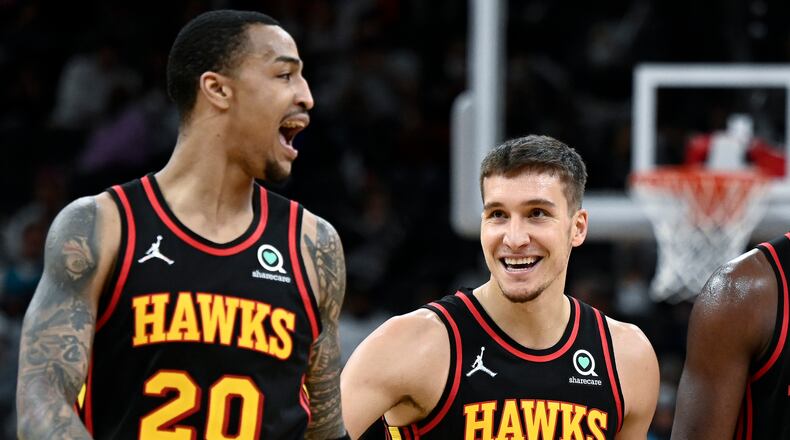 Atlanta Hawks' Bogdan Bogdanovic (13) and John Collins celebrate a basket late in the second half of an NBA basketball game against the San Antonio Spurs, Wednesday, Nov. 24, 2021, in San Antonio. Atlanta won 124-106. (AP Photo/Darren Abate)