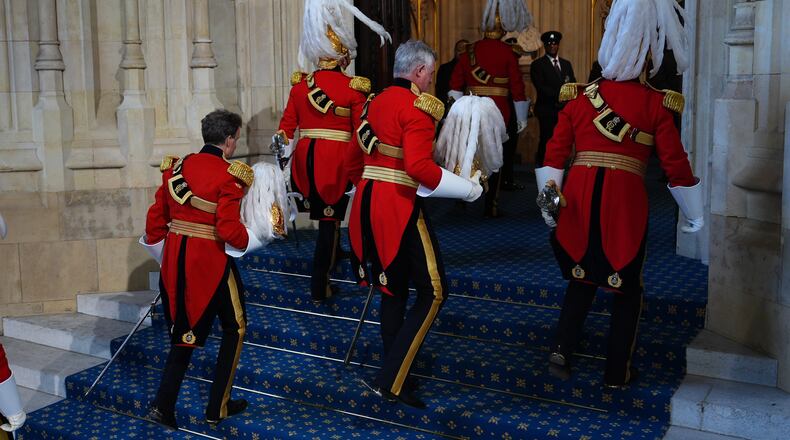 Members of the King's Body Guards of the Honourable Corps of Gentlemen at Arms arrive at the Sovereign's Entrance for the State Opening of Parliament in the House of Lords, in London, Wednesday May 13, 2026. (Aaron Chown/Pool Photo via AP)