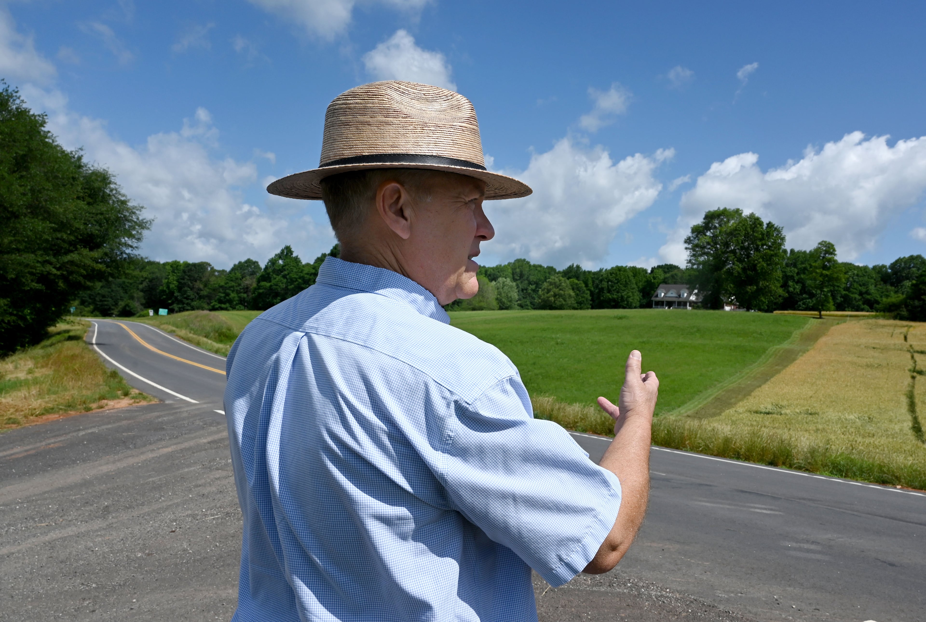 Former state Rep. Dan Gasaway points to the certified county line (on his right) as he talks about the boundary between Banks and Franklin, a boundary that mysteriously moved to the east (one his left), allowing the Banks sheriff to claim he lives in the county, Wednesday, May 21, 2025, in Carnesville. (Hyosub Shin / AJC)