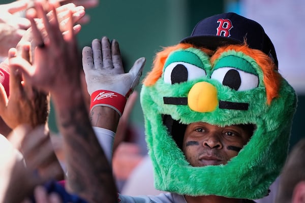 Boston Red Sox's Rafael Devers celebrate in the dugout after hitting a two-run home run during the sixth inning of a baseball game against the Kansas City Royals, Sunday, May 11, 2025, in Kansas City, Mo. (AP Photo/Charlie Riedel)