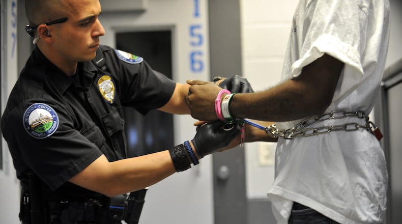 Roswell Detention Center officer, Jason Azar, places handcuffs on a prisoner that was being prepared for transport.