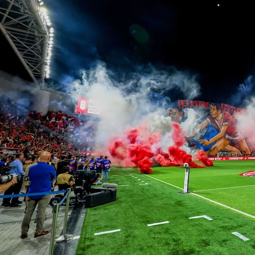 Smoke from flares thrown by fans fills the field before the soccer derby between Maccabi Tel Aviv and Hapoel Tel Aviv was called off Sunday after pregame disturbances led police to deem it unsafe to proceed at Bloomfield Stadium in Tel Aviv, Israel, Sunday, Oct. 19, 2025 . (AP Photo/Nir Keidar)