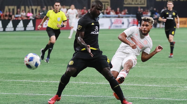 Atlanta United forward Josef Martinez scores in the first half of Sunday's MLS match against the Columbus Crew at Mercedes-Benz Stadium. The goal, scored past Columbus defender Jonathan Mensah, was his 27th of the season, tying the league record for goals in a season. Curtis Compton/ccompton@ajc.com