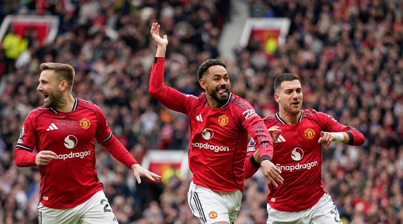 Manchester United's Matheus Cunha, centre, celebrates with teammates after scoring his side's opening goal during the English Premier League soccer match between Manchester United and Liverpool in Manchester, England, Sunday, May 3, 2026. (AP Photo/Dave Thompson)