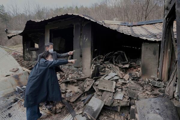 Lee Hae-soo and his wife Byung Jung-ee, left, watch their burnt-out house at a damaged village due to wildfires in Andog, South Korea, Friday, March 28, 2025. (AP Photo/Ahn Young-joon)