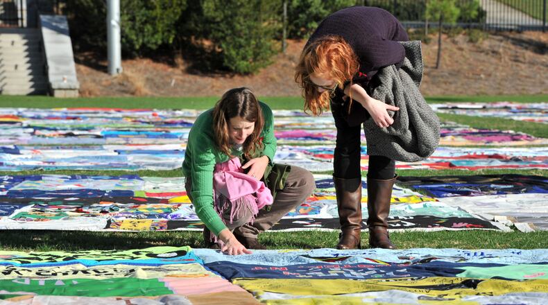 Kate Ogorzaly (left) touched one of AIDS Memorial Quilt displays as Ogorzally and Meg Bertram, then both graduate students majoring Global Health, stop for a closer look in 2011 at the AIDS Memorial Quilt at Emory University’s McDonough Field. Hyosub Shin, hshin@ajc.com