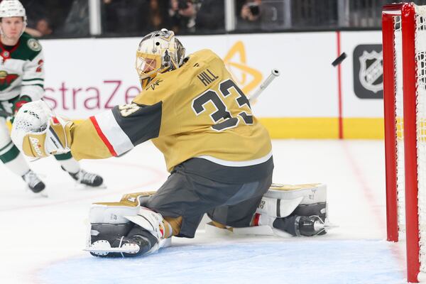 Vegas Golden Knights goaltender Adin Hill (33) attempts to make a save during the first period in Game 1 of an NHL hockey Stanley Cup first-round playoff series against the Minnesota Wild Sunday, April 20, 2025, in Las Vegas. (AP Photo/Ian Maule)