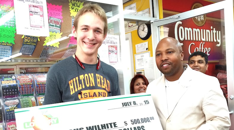 Lottery winner Marcus Wilhite (left) claims his $500K prize from Georgia Lottery sales representative Isaac Robinson.