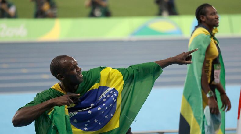 Jamaica's Usain Bolt holds the flag of Brazil after winning the gold medal in the men's 4x100-meter relay final during the athletics competitions of the 2016 Summer Olympics at the Olympic stadium in Rio de Janeiro, Brazil, Friday, Aug. 19, 2016. (AP Photo/David Goldman)
