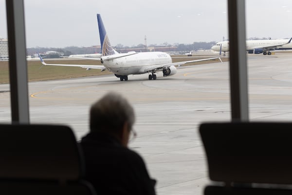   Travelers sit and watch jets depart in the new Concourse T extension at Hartsfield-Jackson Atlanta International Airport Tuesday, December 13, 2022.    (Steve Schaefer/steve.schaefer@ajc.com)