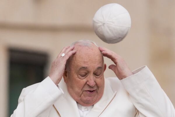FILE - Pope Francis tries to catch his cap as wind blew it away while arriving for his weekly general audience in the St. Peter's Square at the Vatican, Wednesday, March 13, 2024. (AP Photo/Andrew Medichini, File)