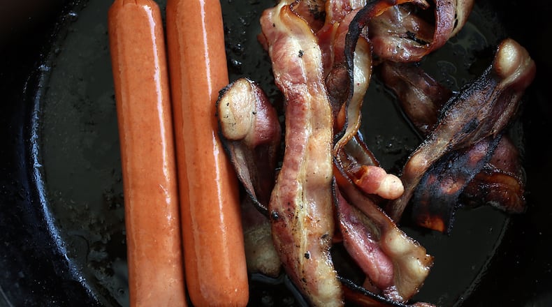 In this photo illustration, processed meats, including hot dogs and bacon, cook in a frying pan on October 26, 2015 in Miami, Florida. A report released today by the World Health Organization's International Agency for Research on Cancer announced that eating processed meat can lead to colorectal cancer in humans even as it remains a small chance but rises with the amount consumed. (Photo illustration by Joe Raedle/Getty Images)