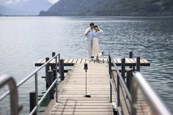 Korean visitors take pictures on the pier at Lake Brienz in Iseltwald, Switzerland, Sunday, May 21, 2023. (Peter Klaunzer/Keystone via AP)