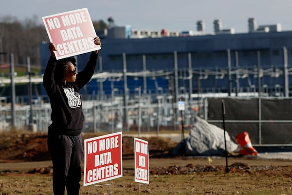 Wanda Mosley of South Fulton held a sign protesting the construction of a Microsoft data center in Union City last week. (Miguel Martinez/AJC)