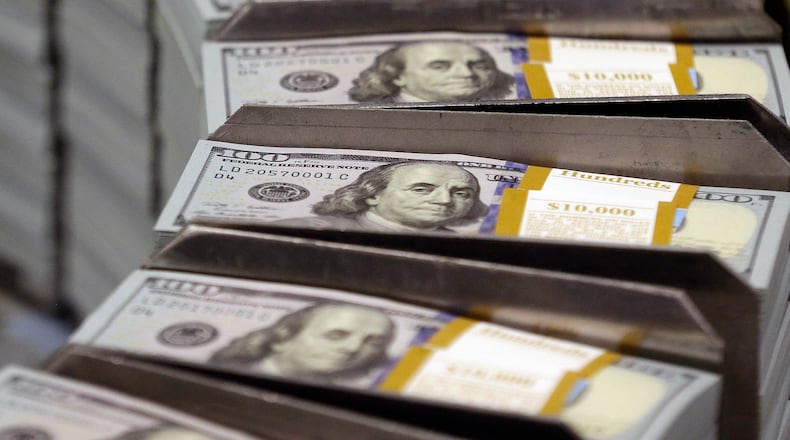 Freshly cut stacks of $100 bills make their way down the line at the Bureau of Engraving and Printing Western Currency Facility in Fort Worth, Texas. More Georgians are defaulting on their student loans, according to new reporting by the Associated Press. (AP FILE)