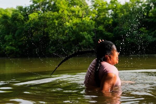 Sevlin Mendez cools off in the Harpeth River as the heat index reaches 100 degrees Fahrenheit, Wednesday, June 25, 2025, in Nashville, Tenn. (AP Photo/George Walker IV)