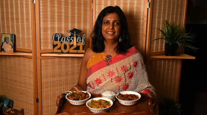 Sukanya Kar Bhowmik, who embraces her Bengali heritage by preparing traditional dishes she learned from her mother and grandmother, shows three of her dishes: (from left) Loitta Shurkir Jhal (Dry Bombay Duck Curry), Lau Chingri (Bottle Gourd Curry with Shrimp), and Chitol Macher Muithya (Bengali Fish Curry). (Styling by Sukanya Kar Bhowmik / Chris Hunt for the AJC)