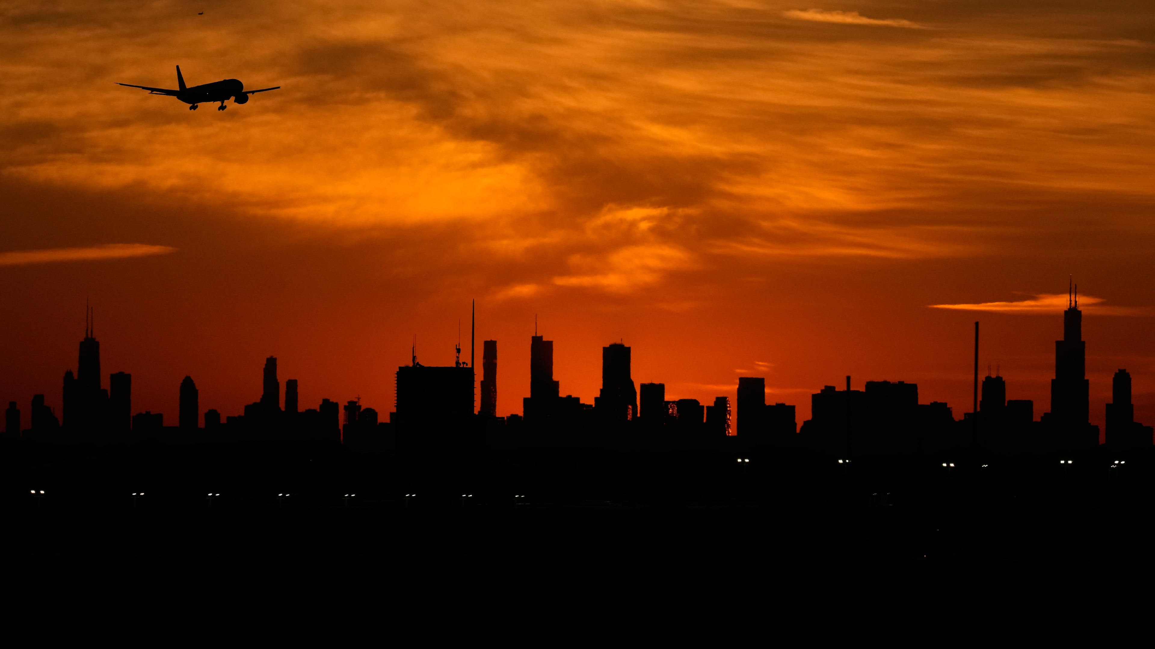 An airplane descends to land at O'Hare International Airport in Chicago, Wednesday, Nov. 12, 2025. (AP Photo/Nam Y. Huh)