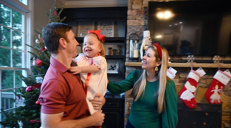 Andi and Ryan Mahoney play with their daughter Emmie at their home in Milton. Emmie was born without kidneys and was given little chance of survival. Now she is considered a medical marvel and is spending her first Christmas at home. (Hyosub Shin / Hyosub.Shin@ajc.com)