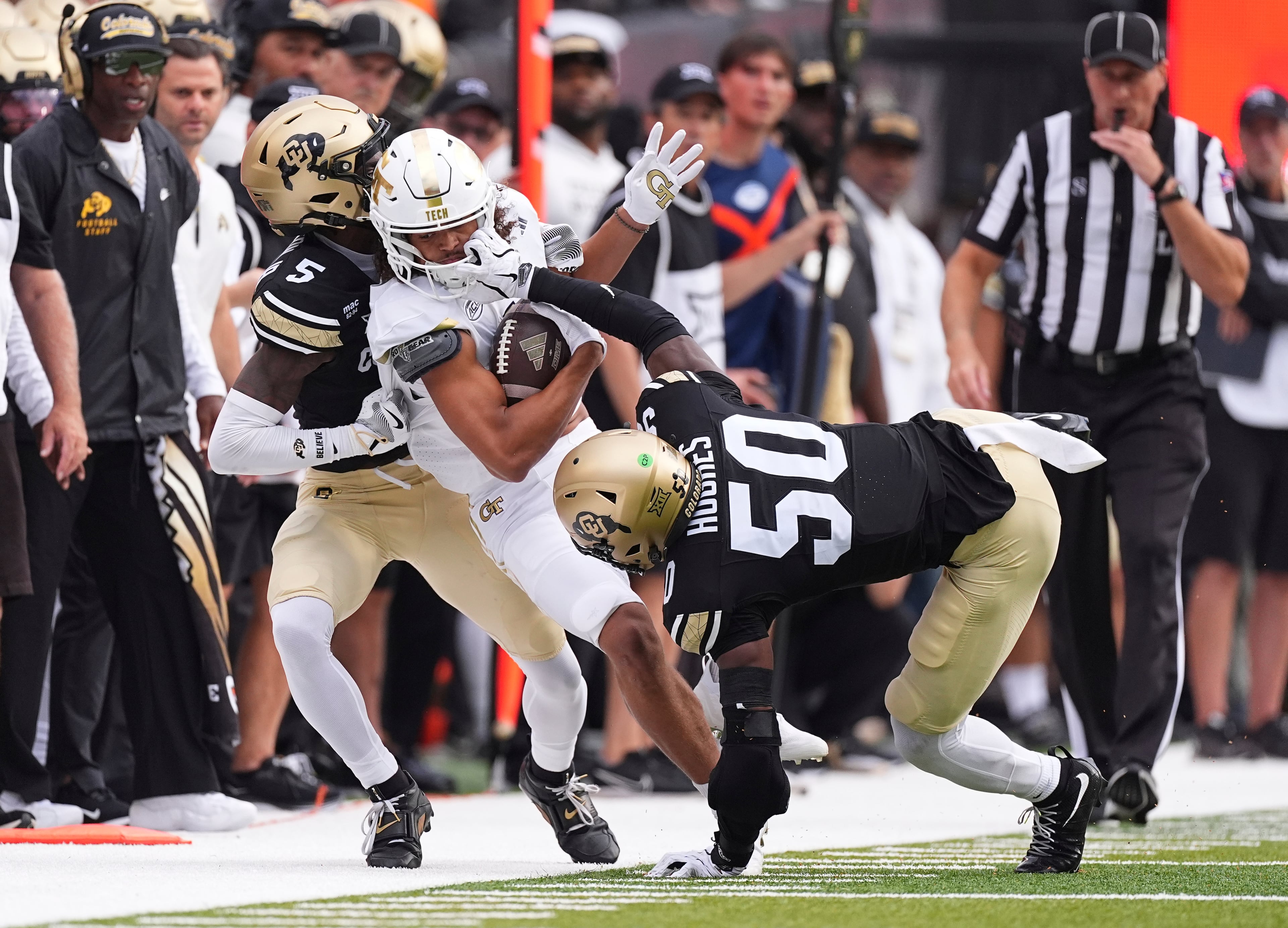 Georgia Tech wide receiver Isiah Canion, center, is tackled after pulling in a pass by Colorado cornerback Preston Hodge, left, and linebacker Reginald Hughes in the first half of an NCAA college football game Friday, Aug. 29, 2025, in Boulder, Colo. (AP Photo/David Zalubowski)