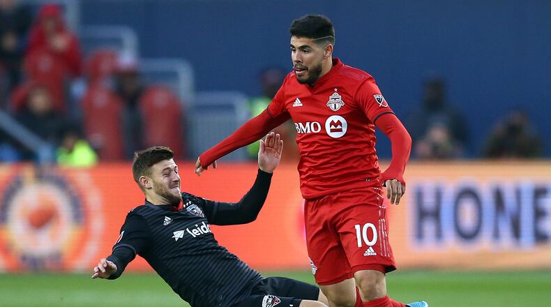 Alejandro Pozuelo #10 of Toronto FC is tackled by Paul Arriola #7 of D.C. United during an MLS First Round Playoff game at BMO Field on October 19, 2019 in Toronto, Canada.  (Photo by Vaughn Ridley/Getty Images)