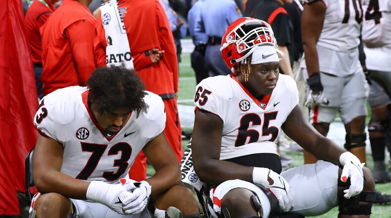 Georgia offensive lineman Xavier Truss (left) and Amarius Mims sit dejected and stunned on the sidelines in the final minutes of a 41-24 loss to Alabama in the SEC Championship game on Saturday, Dec 4, 2021, in Atlanta. “Curtis Compton / Curtis.Compton@ajc.com”`