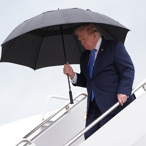 President Donald Trump carries an umbrella as he exits Air Force One at Joint Base Andrews, Md., Sunday, Aug. 2, 2026, on return to Washington. (AP Photo/Jacquelyn Martin)