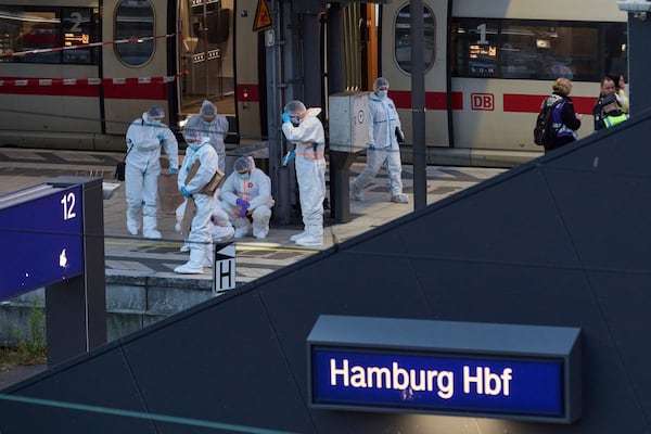 Investigators work at Hamburg, Germany's Central Station on Friday, May 23, 2025, after several people were injured in a knife attack. (Georg Wendt/dpa via AP)