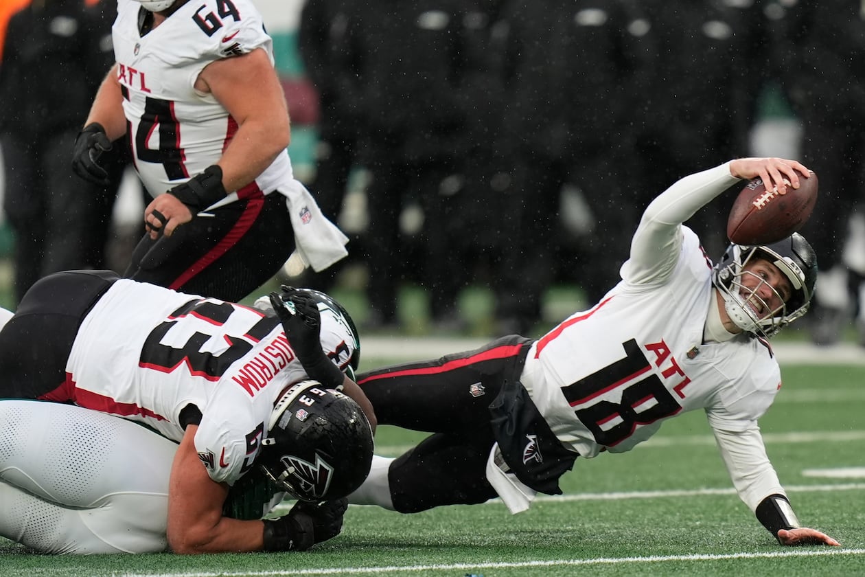 Atlanta Falcons quarterback Kirk Cousins (18) is tackled against the New York Jets during the first half of an NFL football game, Sunday, Nov. 30, 2025, in East Rutherford, N.J. (AP Photo/Seth Wenig)