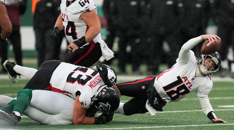 Atlanta Falcons quarterback Kirk Cousins (18) is tackled against the New York Jets during the first half of an NFL football game, Sunday, Nov. 30, 2025, in East Rutherford, N.J. (AP Photo/Seth Wenig)