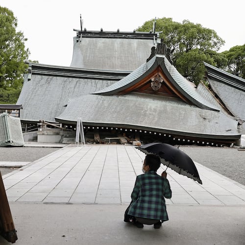 A visitor looks at the fallen roofs of the Yatsuhiro Shrine, a day after an earthquake in Yatsushiro, Kumamoto prefecture, Wednesday, July 29, 2026.(Juntaro Yokoyama/Kyodo News via AP)