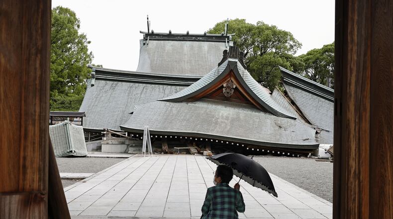A visitor looks at the fallen roofs of the Yatsuhiro Shrine, a day after an earthquake in Yatsushiro, Kumamoto prefecture, Wednesday, July 29, 2026.(Juntaro Yokoyama/Kyodo News via AP)
