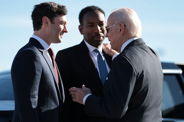 Democratic U.S. Sen. Jon Ossoff, left, Atlanta Mayor Andre Dickens, center, and President Joe Biden talk during the president's visit to Atlanta in January. Democrats are trying to link Georgia's boom in green energy jobs to Biden's climate initiatives. (Oliver Contreras/The New York Times)