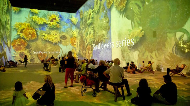 People sit and watch the two-story projections during the Van Gogh: The Immersive Experience at the Pullman Yard in Atlanta Thursday, May 20, 2021.  STEVE SCHAEFER FOR THE ATLANTA JOURNAL-CONSTITUTION