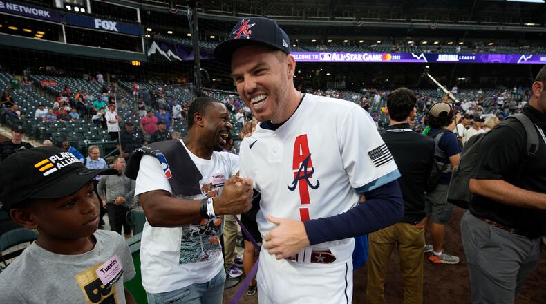 National League's Freddie Freeman, of the Atlanta Braves, laughs with former player Michael Bourn during batting practice prior to the MLB All-Star baseball game, Tuesday, July 13, 2021, in Denver. (AP Photo/David Zalubowski)