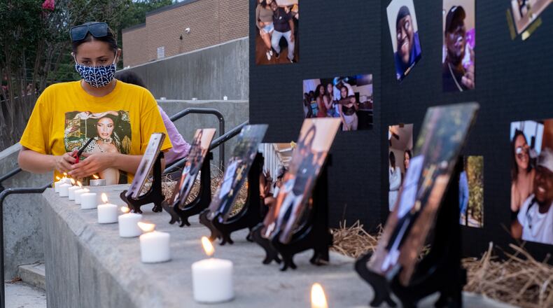 Rachel Pinkerton lights candles before a memorial service for Kyle Gregory at Brookwood High School on Friday evening July 24, 2020. Gregory, who died from COVID-19, played football at Brookwood and then went to Georgia Southern University. Pinkerton was a classmate at both schools. (Ben Gray for the Atlanta Journal-Constitution)