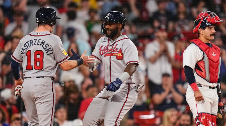 Atlanta Braves' Michael Harris II, center, is congratulated by Mike Yastrzemski (18) after his two-run home run, as Boston Red Sox's Mickey Gasper (30) waits for play to resume, during the eighth inning of a baseball game, Tuesday, May 26, 2026, in Boston. (AP Photo/Charles Krupa)