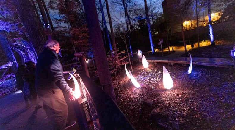 A man interacts with the Wildwoods: AGLOW Experience at the Fernbank Museum in Atlanta, GA, on Friday, December 2, 2022.(Photo/Jenn Finch)