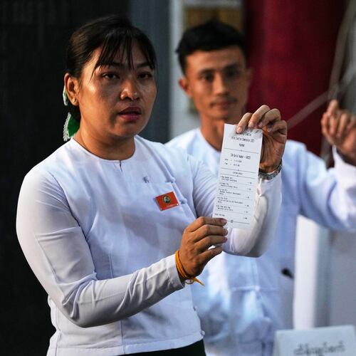 An official of the Union Election Commission shows a slip as they count ballots at a polling station during the second phase of general election in Yangon, Myanmar, Sunday, Jan. 11, 2026. (AP Photo/Thein Zaw)