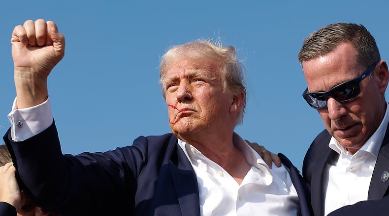 Republican presidential candidate former President Donald Trump pumps his fist as he is rushed offstage July 13 by Secret Service agents after an apparent assassination attempt at a campaign rally in Butler, Pa. (Anna Moneymaker/Getty Images/TNS)