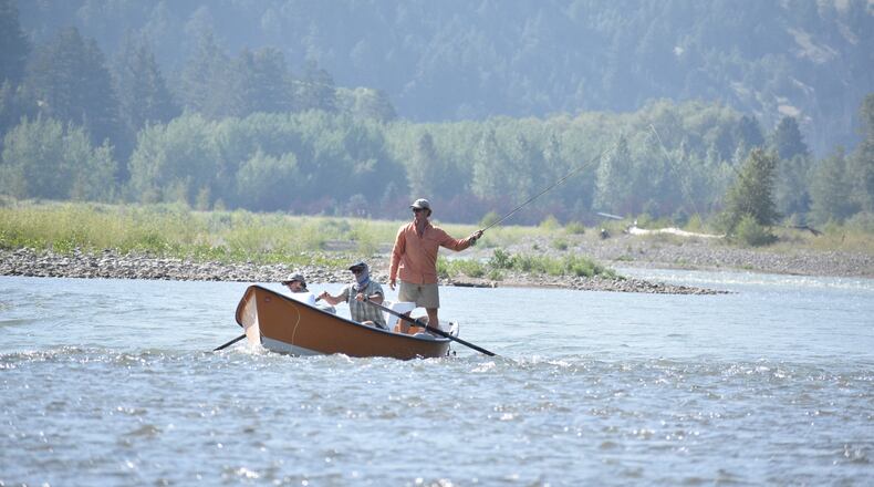 A drift boat with people fly fishing floats down the Yellowstone River, Friday, July 31, 2026, near Livingston, Montana. (AP Photo/Matthew Brown)