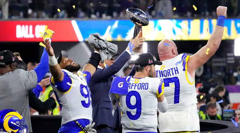 Los Angeles Rams defensive end Aaron Donald (99), quarterback Matthew Stafford (9) and offensive tackle Andrew Whitworth react after winning the Super Bowl. Rams coach Sean McVay and general manager Les Snead are not attending the NFL scouting combine, but other teams still find value in the event. (AP Photo/Julio Cortez)