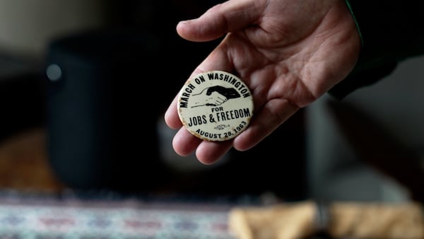 In this still image taken from video, a button from the March on Washington for Jobs an Freedom is held by Walter Naegle, Bayard Rustin's partner and a consultant on projects related to his life and work, on Saturday, June 28, 2025, in New York (AP Photo/Mary Conlon)