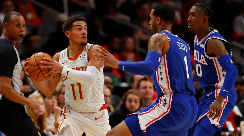 Hawks guard Trae Young looks to pass out of the trap set by Philadelphia's Mike Scott (1) and Josh Richardson (0) during the first half Oct. 28, 2019, at State Farm Arena in Atlanta.