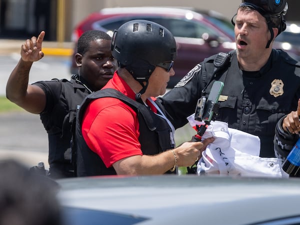 Police tell Spanish-language reporter Mario Guevara to move back during a protest on ICE raids and deportation arrests on Chamblee Tucker Road in Atlanta on Saturday, June 14, 2025. (Arvin Temkar / AJC)